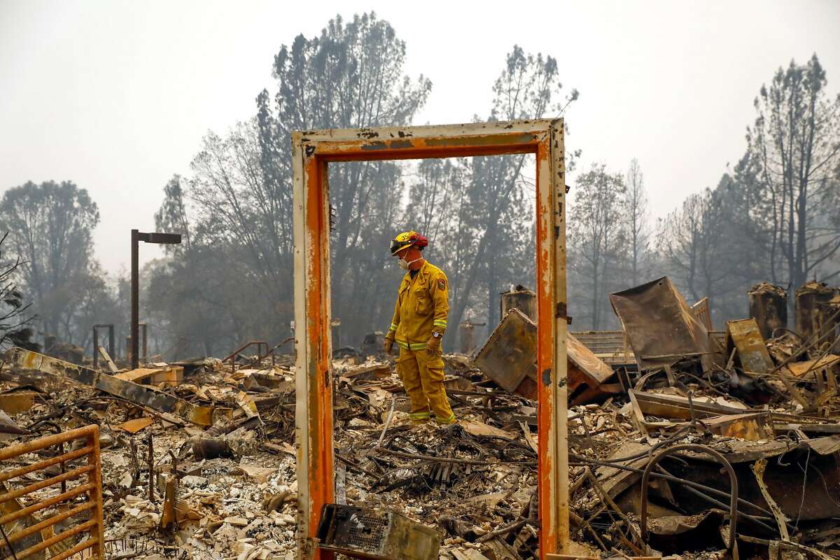 Paradise Firefighter Mike Rea surveys a property for remains at the Paradise Community Village Apartments following the Camp Fire in Paradise, California, on Tuesday, Nov. 13, 2018.