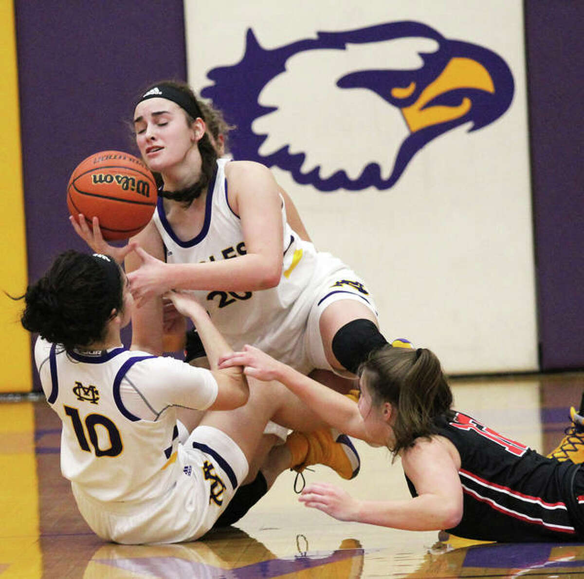 CM’s Kourtland Tyus (10) and Anna Hall beat Highland’s Mae Riffel (right) to a loose ball at the Bulldogs’ end during the first half of Thursday’s Mississippi Valley Conference game in Bethalto.