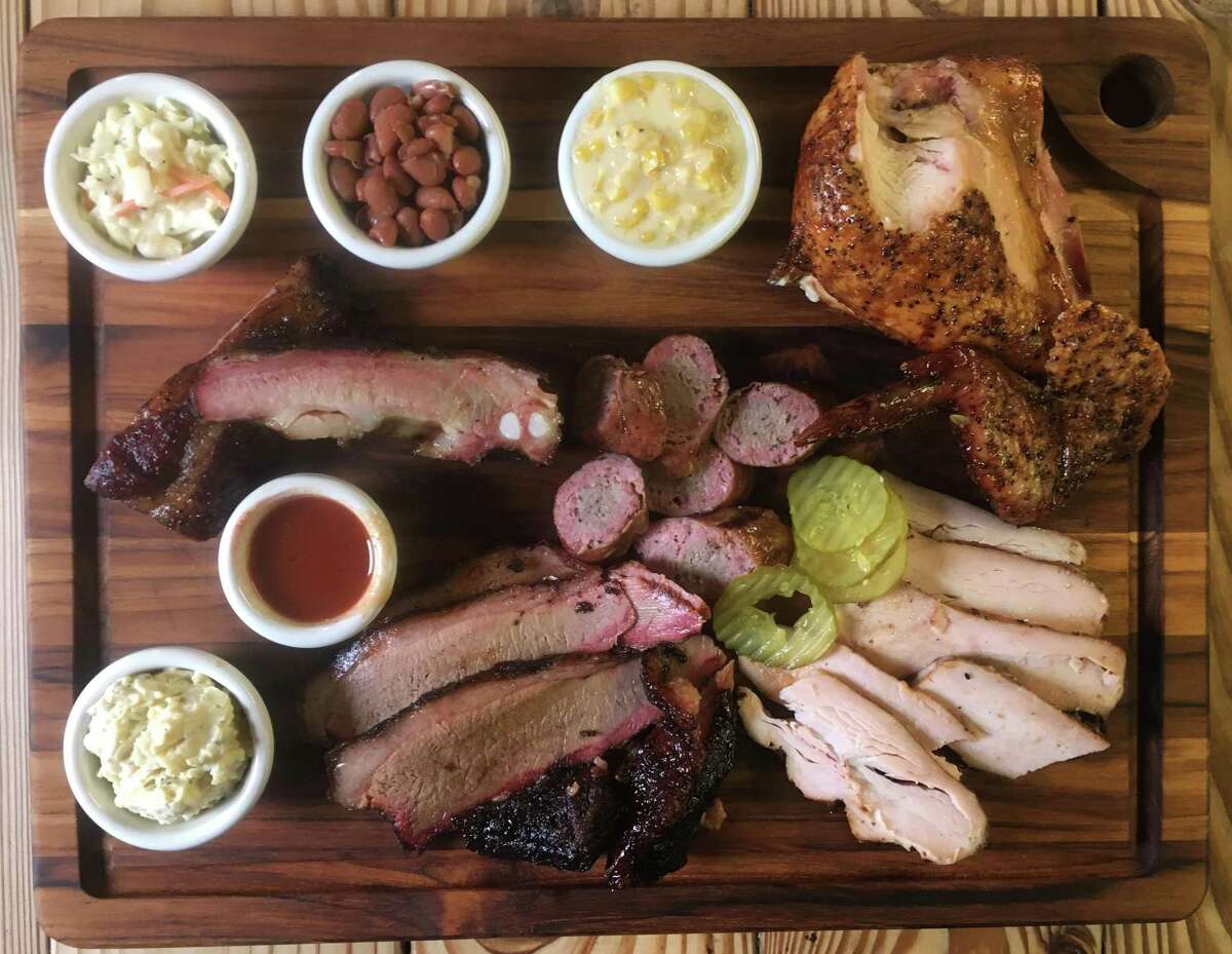 The Heavy's Bar-B-Que board with (from top left) cole slaw, beans, creamed corn, chicken, turkey, sausage, brisket, potato salad and pork ribs.