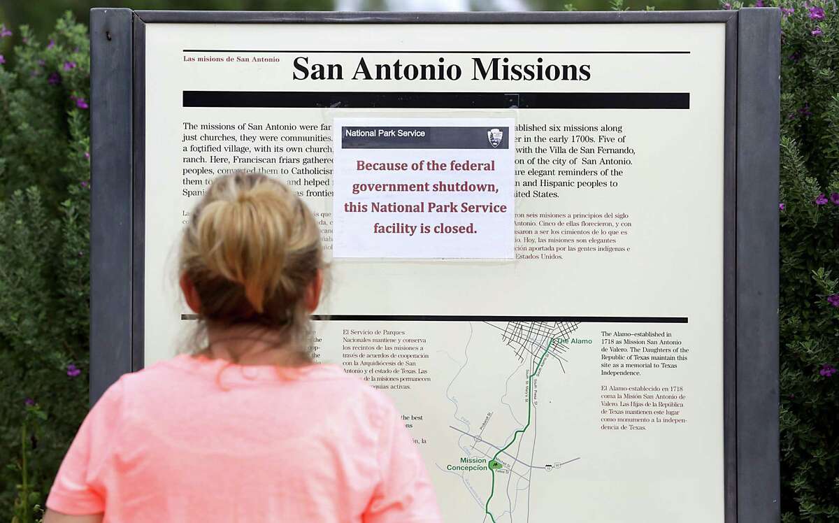 Cathy Tappon of Wisconsin stops to read the sign at Mission San José stating the National Park is closed due to the government shutdown in this 2013 photo.