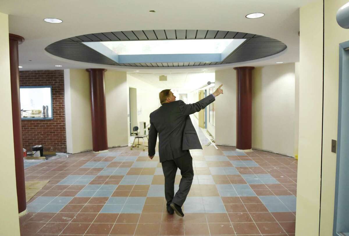Principal Gene Schmidt shows the newly-repaired main entrance lobby at Cos Cob School in the Cos Cob section of Greenwich, Conn. Wednesday, Dec. 19, 2018. Displaced Cos Cob School kindergartners, first- and second-graders will return on Jan. 2, concluding nearly three months in makeshift classrooms at Parkway and Old Greenwich Schools after major flooding caused damage forcing students to be relocated.