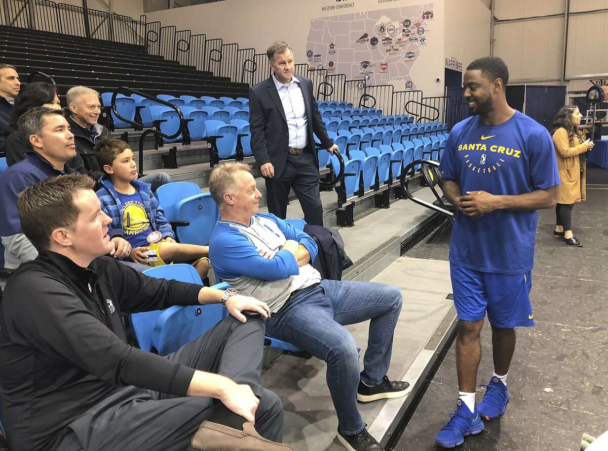 In this Dec. 4, 2018 photo, from left, Santa Cruz Warriors coach Aaron Miles visits with fans and sponsors after their basketball practice in Santa Cruz, Calif. As the Santa Cruz Warriors huddled together after practice, Darius Morris gave a quick recap of his adventure to the Arizona desert a day earlier to interview with the Suns. Phoenix needed a point guard with Devin Booker's hamstring injury, and Morris was in the mix. Coach Aaron Miles, who so wishes he were still playing, had to stand in leading the offense given Morris' absence. Such is life in the topsy-turvy, changing-by-the-day G League, when Golden State or another club might come calling at a moment's notice to swipe a top player for promotion to the NBA. (AP Photo/Janie McCauley)