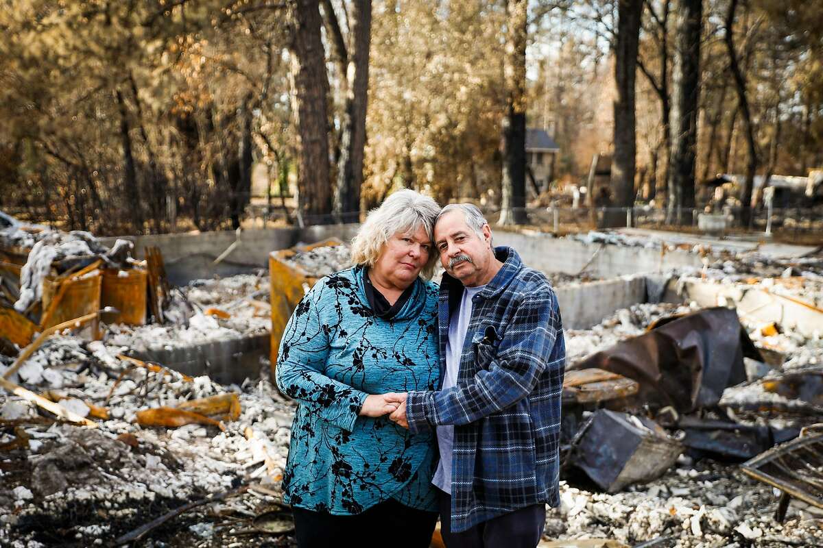 (l-r) Susan Matoes and her husband Frank Matoes stand in front of their property which was destroyed in the Camp Fire in Paradise, California, on Wednesday, Dec. 19, 2018. The Matoes' previous home was destroyed in the Tubbs Fire last year in Santa Rosa.