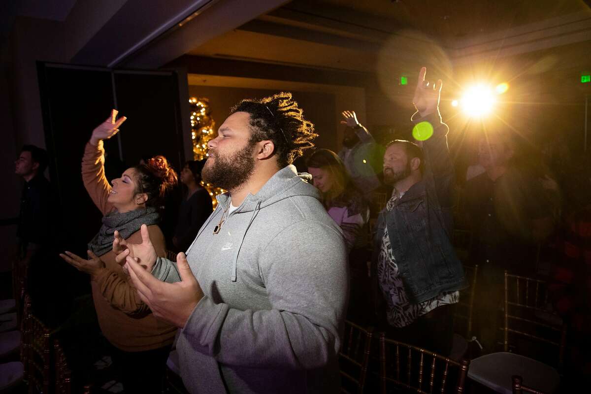 Jordan Lee, of Campbell, prays during CenterSet church services at Hotel Valencia Santana Row on Sunday, Dec. 9, 2018, in San Jose, Calif. Ali Roohi left behind a career in engineering to become a pastor in Silicon Valley.