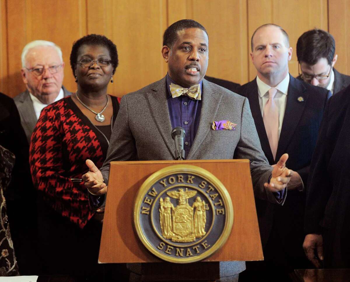 FILE- In this Feb. 6, 2017, file photo, Sen. Kevin Parker, D- Brooklyn, stands at the podium, flanked by Senate members during a news conference at the Capitol in Albany, N.Y. Parker wants to require police to scrutinize social media activity and online searches of handgun license applicants, and disqualify those who make violent or hateful posts. The bill's fate is uncertain amid questions from free-speech advocates. (AP Photo/Hans Pennink, File)