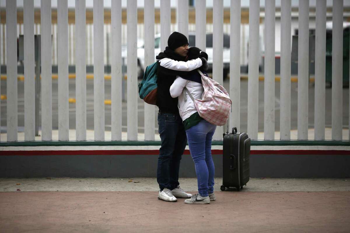 Un par de migrantes se abrazan después de recibir uno de los 50 turnos para solicitar asilo en EU, en Tijuana, México, el viernes.