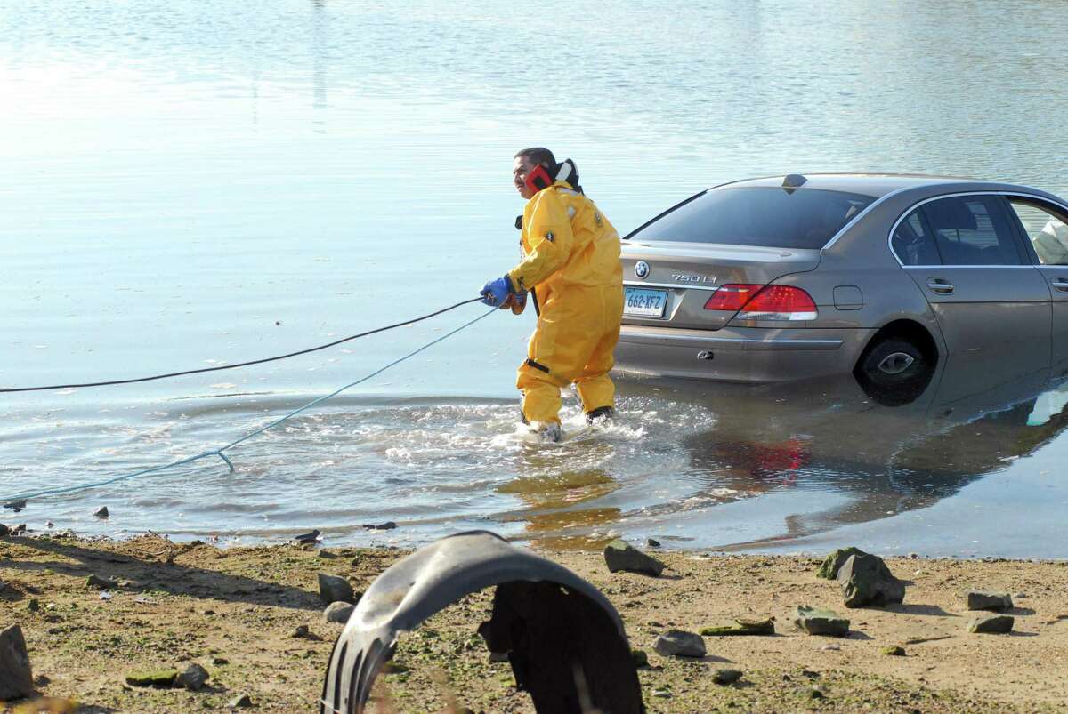 Firefighter Erwin Osorio hooks a cable to Cesar Rodriguez's car to pull it out of the water at Cummings Beach after it was bumped in an apparent road rage incident on Dec. 30, 2011.