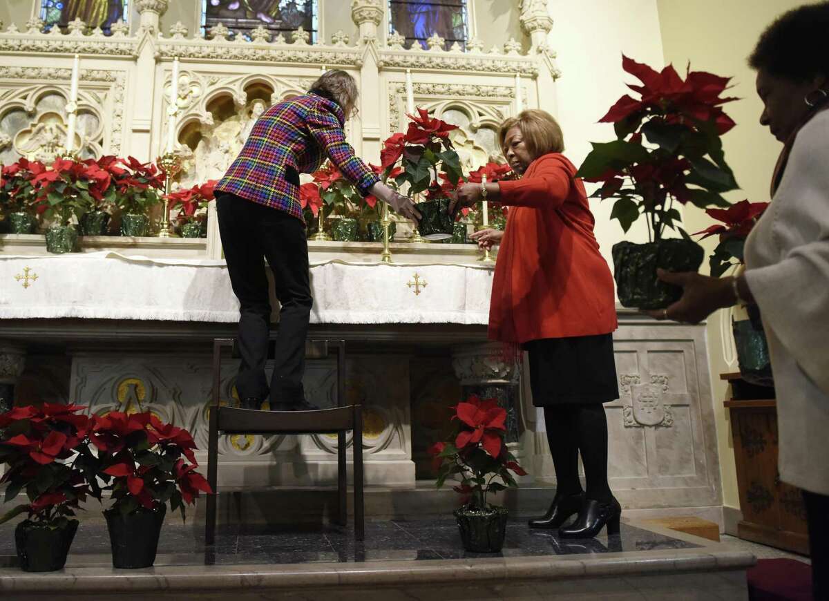 Altar Guild Administrator Mary Carolyn Morgan, left, and Altar Guild member Enid Blaine set up Poinsettias in preparation for the Christmas Day service at St. Andrew's Episcopal Church in Stamford, Conn. Sunday, Dec. 23, 2018.
