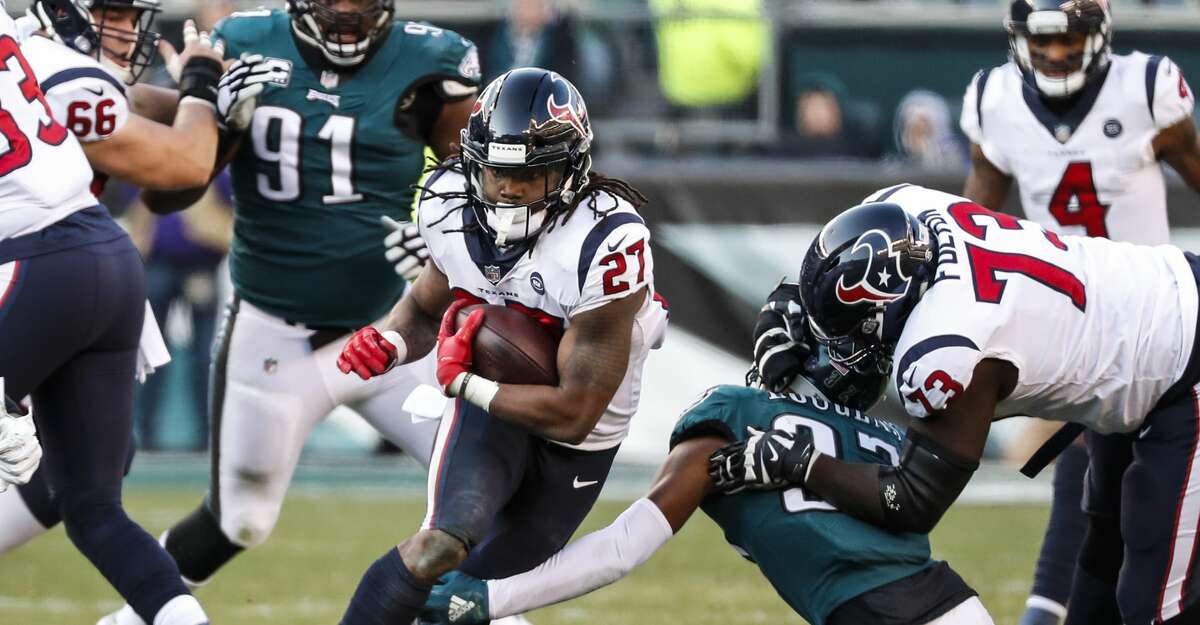 Houston Texans running back D'Onta Foreman (27) is tripped up by Philadelphia Eagles defensive back Tre Sullivan (37) as he runs up the middle during the third quarter of an NFL football game at Lincoln Financial Field on Sunday, Dec. 23, 2018, in Philadelphia.