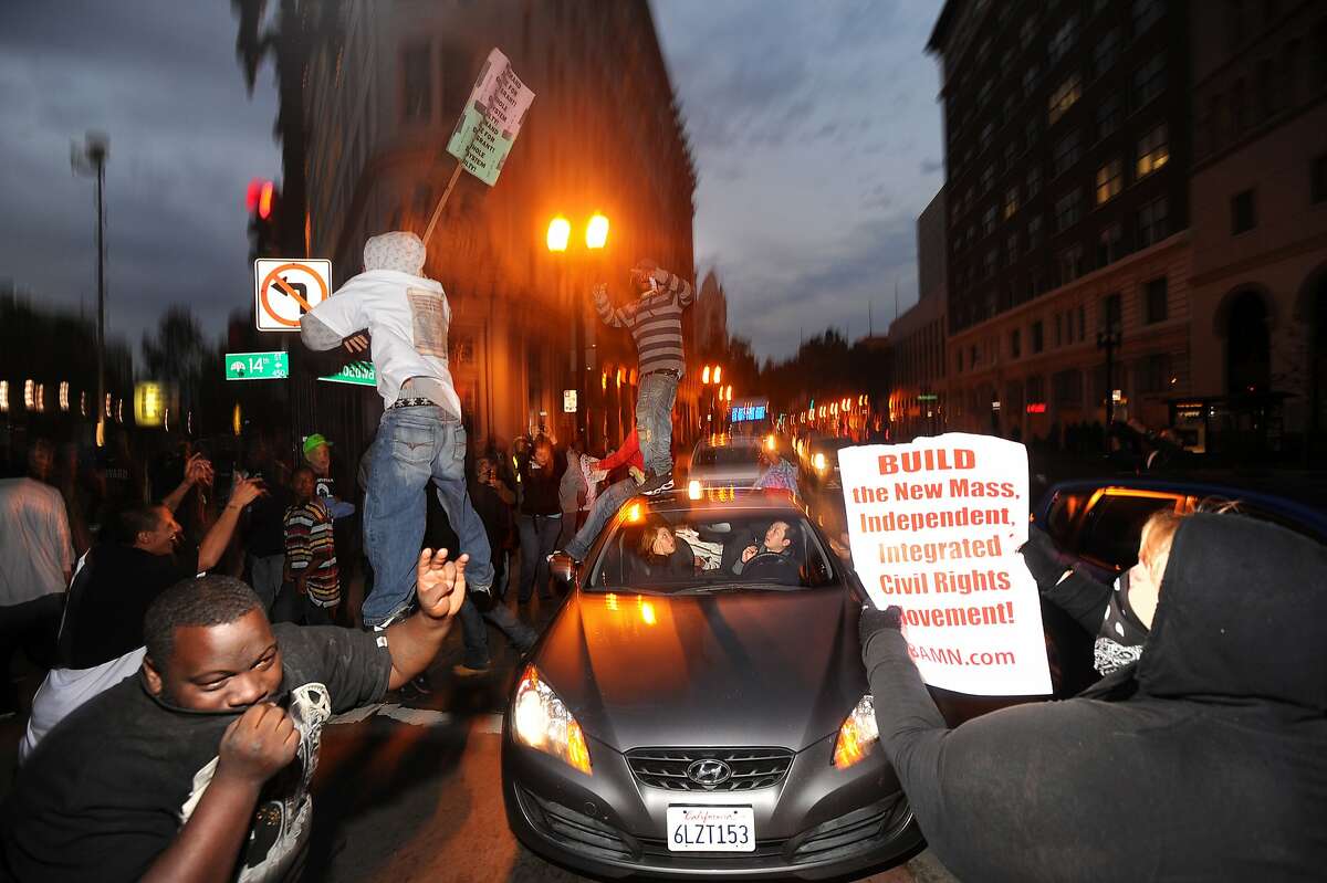 Motorists in Oakland, Calif., react as demonstrators jump on their car following the sentencing of Johannes Mehserle on Friday, Nov. 5, 2010. Mehserle, a former police officer who fatally shot unarmed black man Oscar Grant on New Year's Day 2009, received a two year prison sentence. (AP Photo/Noah Berger)