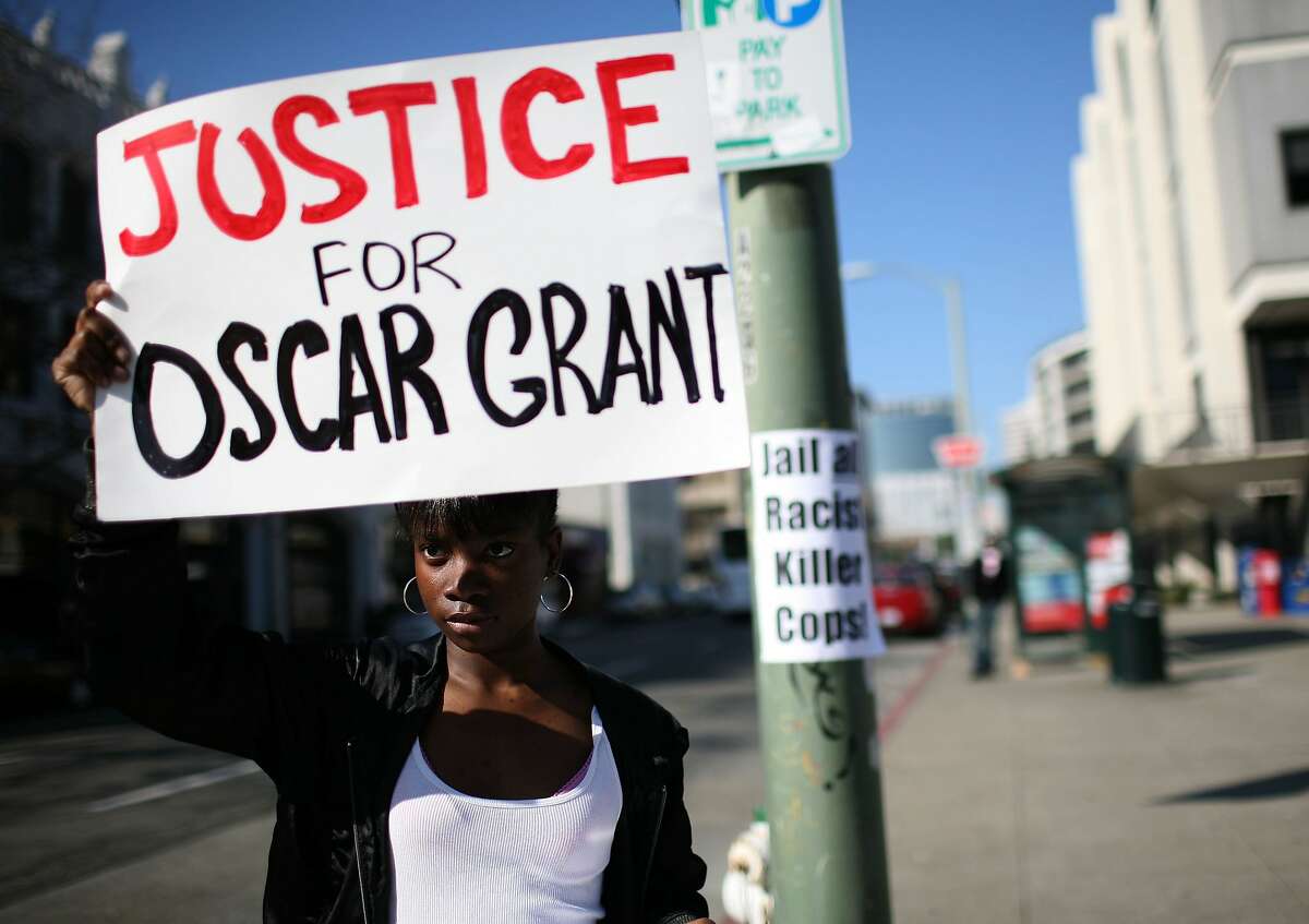 OAKLAND, CA - JANUARY 30: Javone Sloan holds a sign saying "Justice For Oscar Grant" during a protest of court case involving a Bay Area transit officer outside of the Alameda County Superior Court January 30, 2009 in Oakland, California. A three million dollar bail was set for former BART police Officer Johannes Mehserle, who was arrested for murder after he shot and killed an unarmed man on New Years Day. (Photo by Justin Sullivan/Getty Images)