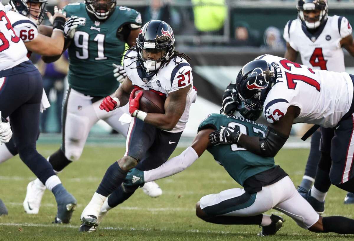 Houston Texans running back D'Onta Foreman (27) is tripped up by Philadelphia Eagles defensive back Tre Sullivan (37) as he runs up the middle during the third quarter of an NFL football game at Lincoln Financial Field on Sunday, Dec. 23, 2018, in Philadelphia.