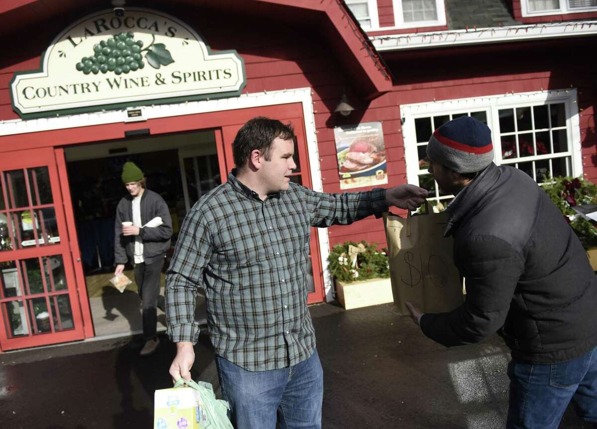 Stamford’s Dave Ranta gives a food donation to Jeff Fortmann for New Covenant Center’s food drive at LaRocca’s Country Market in Stamford on Monday. New Covenant Center accepted cash and food donations, including pre-selected grocery bags ranging from five dollars to 20 dollars available to pick up in the checkout line.