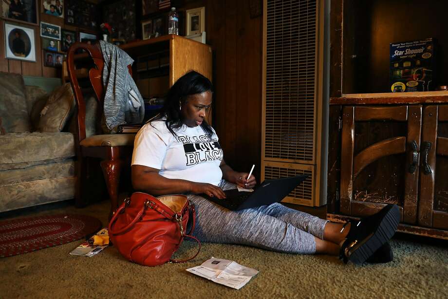 Wanda Johnson works on payroll while sitting in her mother's den in Hayward, Calif., on Saturday, December 1, 2018. When she isn't working as a manager at the United Parcel Service, Johnson leads the Oscar Grant Foundation. Johnson's son, Oscar Grant, was fatally shot by a BART police officer on January 1, 2009. Photo: Yalonda M. James / The Chronicle