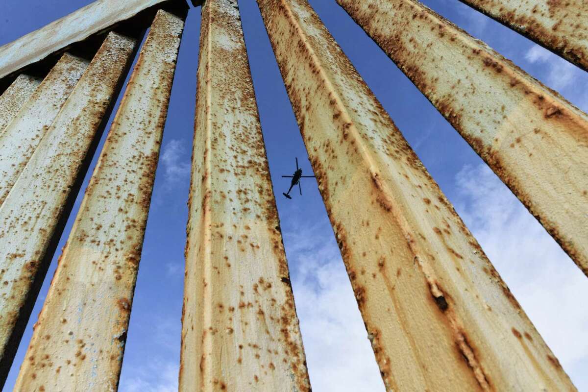 Un helicóptero monitorea la cerca fronteriza de Estados Unidos, visto desde Tijuana, México, el domingo 23 de diciembre de 2018.