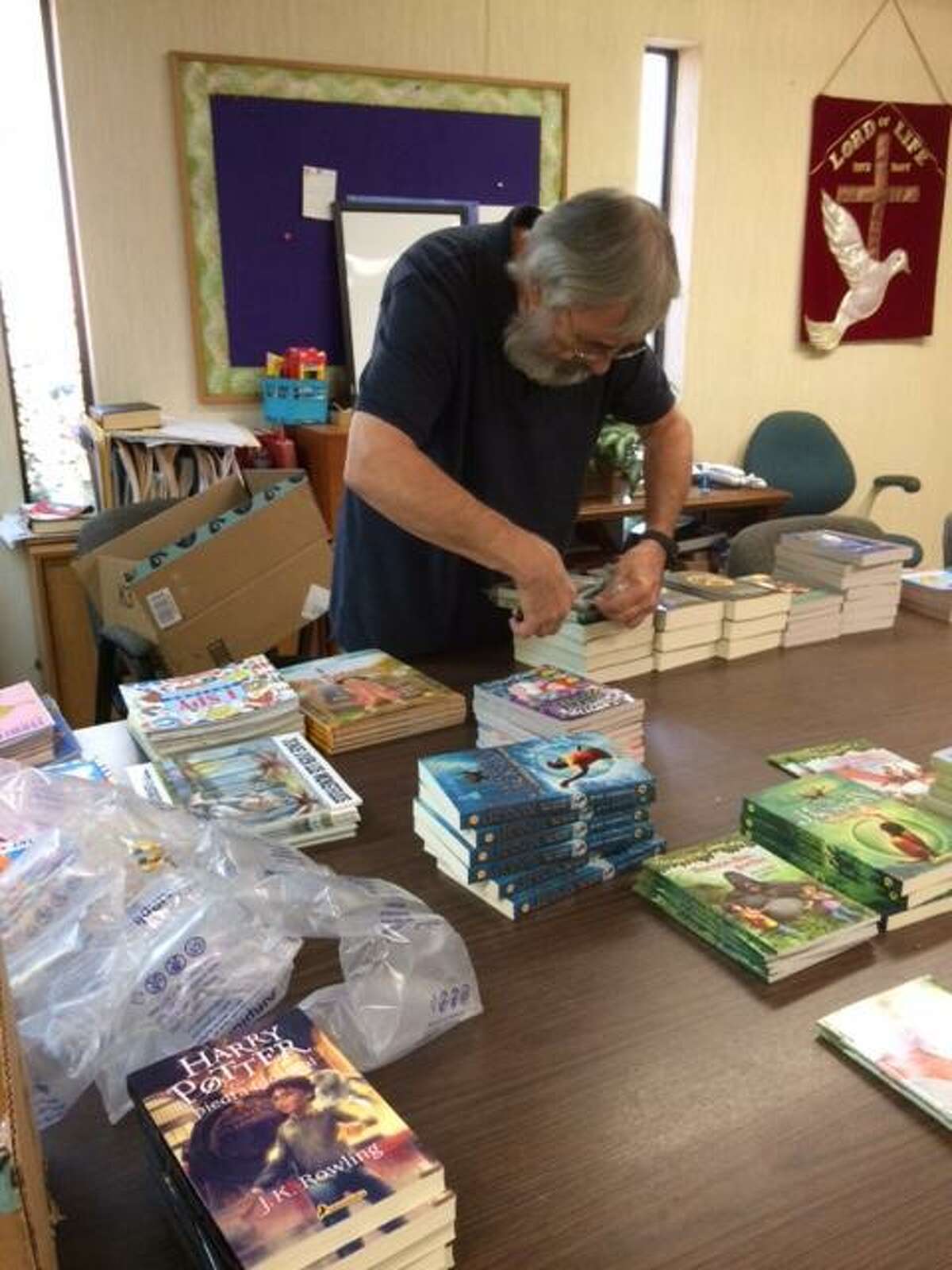 Michael Lawrence-Weden, pastor at Lord of Life Lutheran Church in San Antonio, opens the boxes of gifts and cards in this undated courtesy photo provided by Lawrence-Weden sent to him by the Lutheran Immigration and Refugee Service program. On Monday morning Dec 24, 2018, he and his wife, Rebecca Lawrence-Weden, loaded up the 1,600 cards and 286 children’s books (in Spanish) and delivered them to Dilley’s South Texas Family Residential Center.