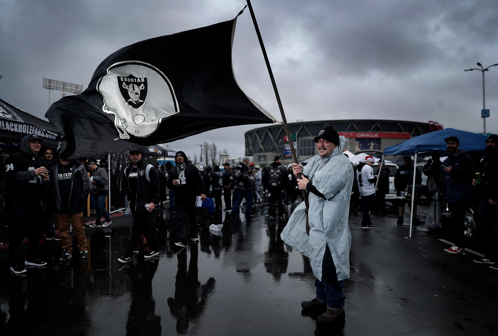 Oakland Raiders fans tailgate in rain at their team's likely last