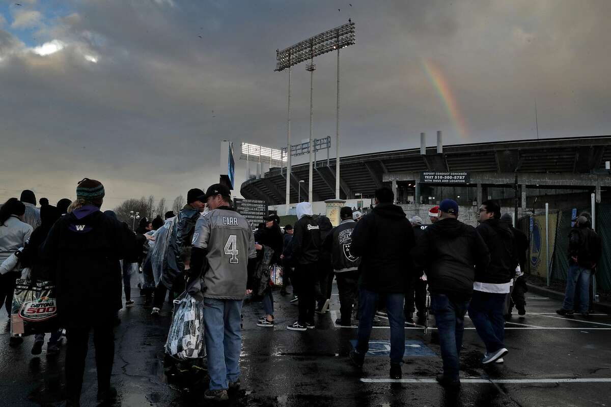 Oakland Raiders fans tailgate in rain at their team's likely last