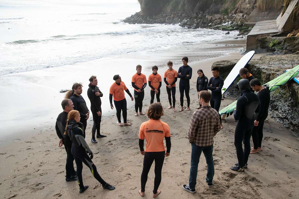 City Surf Project members and Mission High School students circle up before surfing at Private's Beach as on Friday, Dec. 21, 2018, in Santa Cruz, Calif.