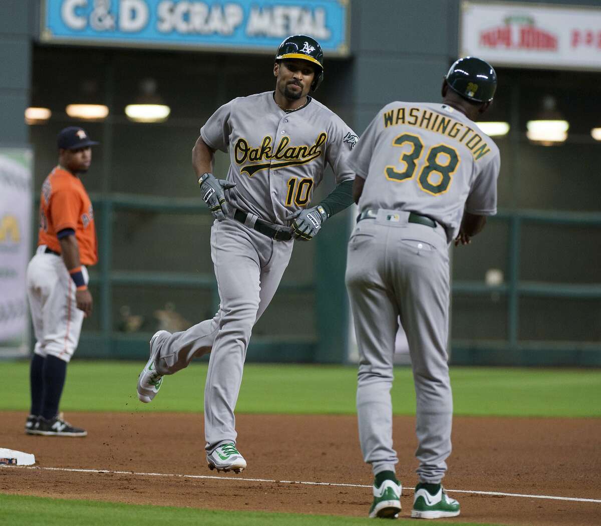 Oakland Athletics' Marcus Semien (10) is congratulated by third base coach Ron Washington (38) after hitting a home run against the Houston Astros in the fourth inning of a baseball game Friday, July 8, 2016, in Houston. (AP Photo/George Bridges)
