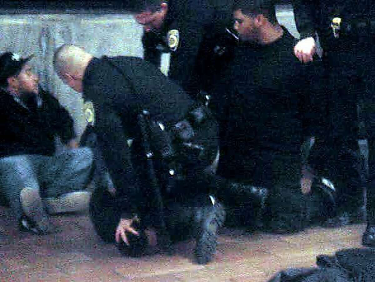 An image from a video of the 2009 BART police shooting of Oscar Grant at Fruitvale Station in Oakland shows the scene just moments before former Officer Johannes Mehserle shot Grant. Former Officer Anthony Pirone can be seen holding Grant's head down with his left hand, with his left knee on Grant's neck. Mehserle is bent over, about to fire his pistol. Two of Grant's friends look on.