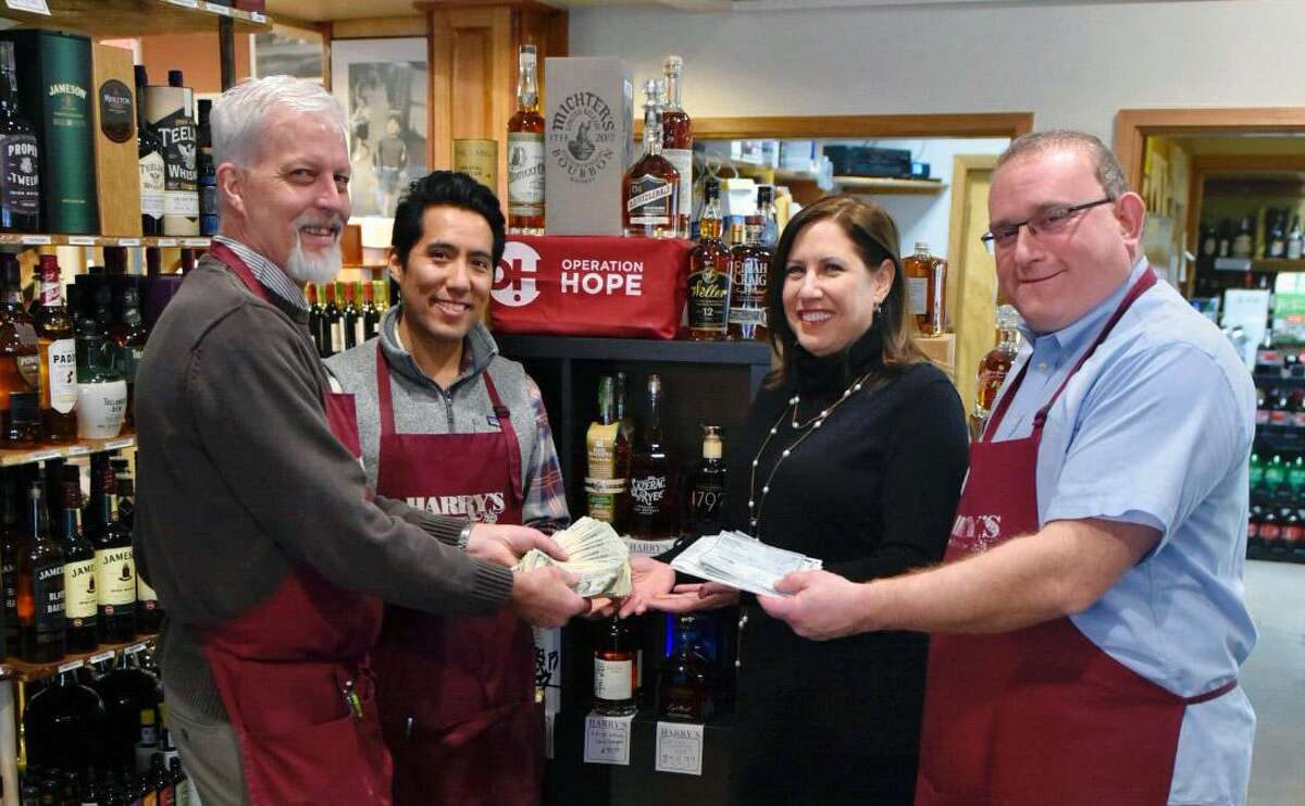 From left, Harry's Wine & Liquor Market co-owner Patrick Monteleone, artisan beer specialist Renzo Kian-Kubota, Operation Hope of Fairfield Executive Director Carla Miklos and Harry's co-owner William Miller hold proceeds from the shop's Rare Bottles?