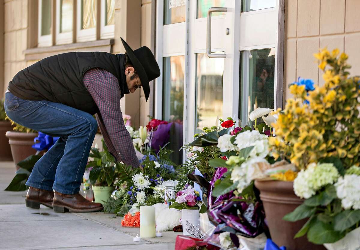 Newman resident Sal Ramirez places flowers at a growing memorial outside of the Newman Police Department in Newman, Calif. Thursday, Dec. 27, 2018 after Newman Police Officer Ronil Singh was shot and killed early Wednesday morning during a traffic stop.