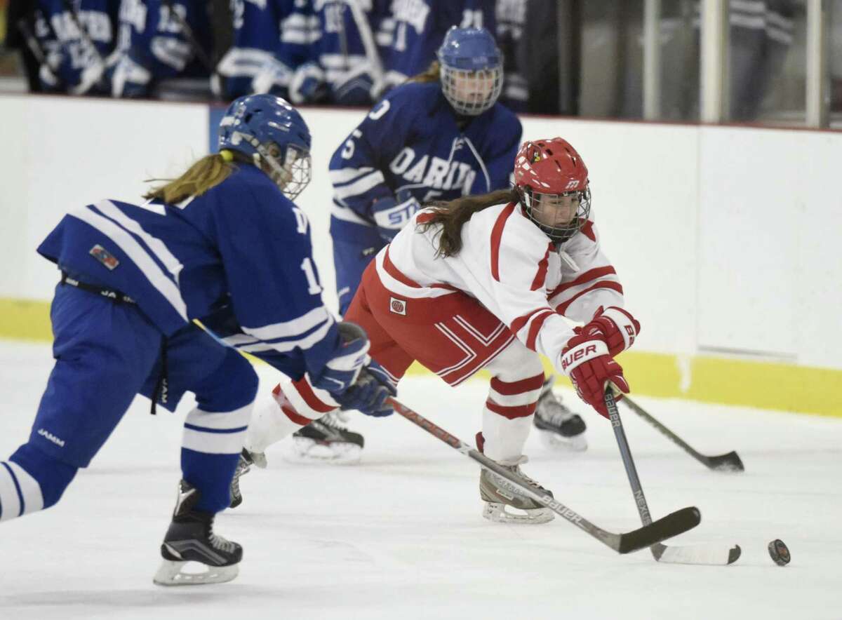 Greenwich’s Paige Finneran, center, and Darien’s Shea van den Broek, left, battle for posession on Feb. 5 at Dorothy Hamill Skating Rink in Greenwich.