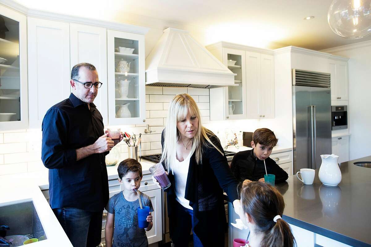 Ramin Ramhormozi (from left), Asher 5, Jenny Romeyn, Avery 5, Owen 9, and in their home in Santa Rosa, California, December 26th, 2018. Jenny Romeyn and her husband Ramin Ramhormozi sold their large home on Skyhawk because they think when all the Fountaingrove homes are rebuilt and on the market, it will be hard to sell a large home in Santa Rosa. They bought a smaller home in need of work near downtown, which is close to both their jobs and their kids' school. They are remodeling the new house and renting back the old house till the end of January.
