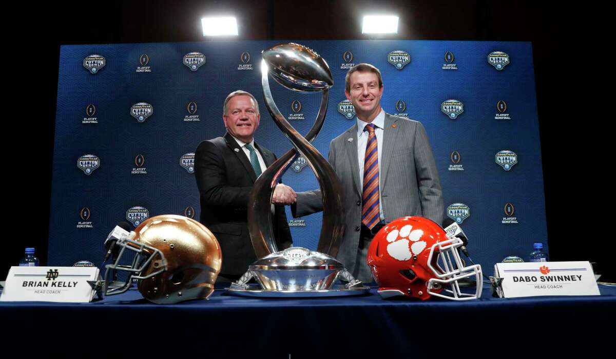 Notre Dame head coach Brian Kelly, left, and Clemson head coach Dabo Swinney shake hands and pose for photos after the NCAA Cotton Bowl football coaches' news conference in Dallas, Friday, Dec. 28, 2018. Notre Dame is scheduled to play Clemson in the NCAA Cotton Bowl semi-final playoff Saturday. (AP Photo/LM Otero)