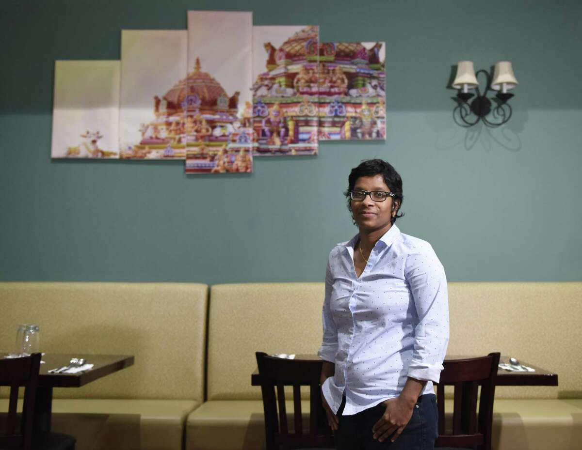 Manager Anitha Gounder poses in front of a photo of the Meenakshi temple, inside the new Indian restaurant Adyar Ananda Bhavan, at 1033 Washington Boulevard in downtown Stamford, Conn., on Thursday, Dec. 20, 2018.