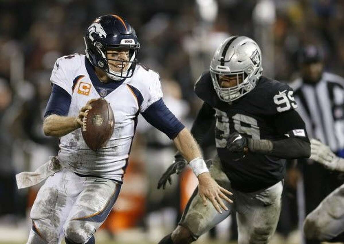 Denver Broncos quarterback Case Keenum, left, scrambles from Oakland Raiders defensive end Arden Key (99) during the second half of an NFL football game in Oakland, Calif., Monday, Dec. 24, 2018. (AP Photo/D. Ross Cameron)