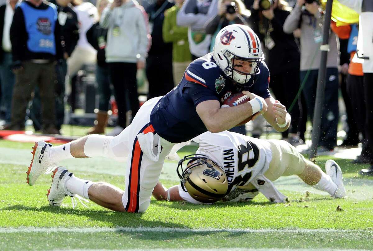 Auburn quarterback Jarrett Stidham (8) drives past Purdue safety Brennan Thieneman (38) and into the end zone in the first half of the Music City Bowl NCAA college football game Friday, Dec. 28, 2018, in Nashville, Tenn. Stidham was ruled down at the 1-yard line.