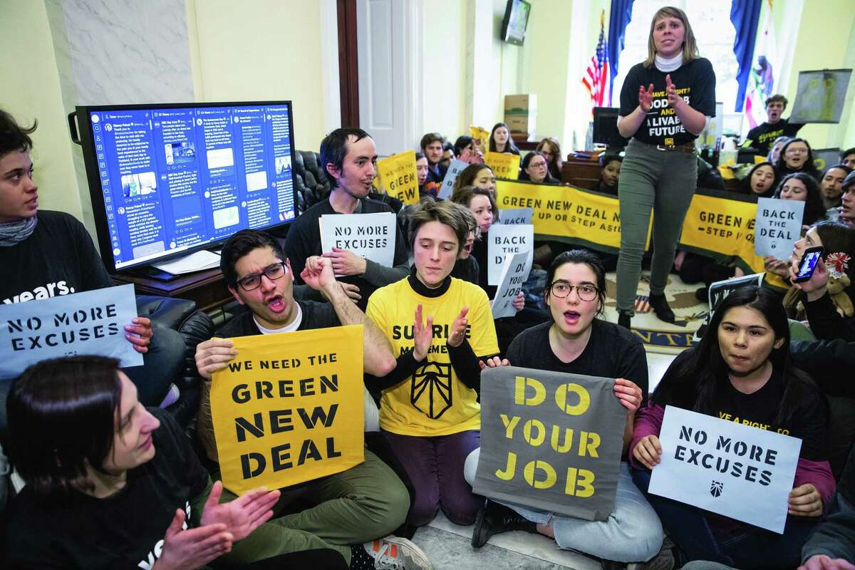 Environmental activists occupy the office of House Democratic Leader Nancy Pelosi of California, the speaker-designate for the new Congress, as they try to pressure Democratic support for a sweeping agenda to fight climate change, on Capitol Hill in Washington, Monday, Dec. 10, 2018. (AP Photo/J. Scott Applewhite)