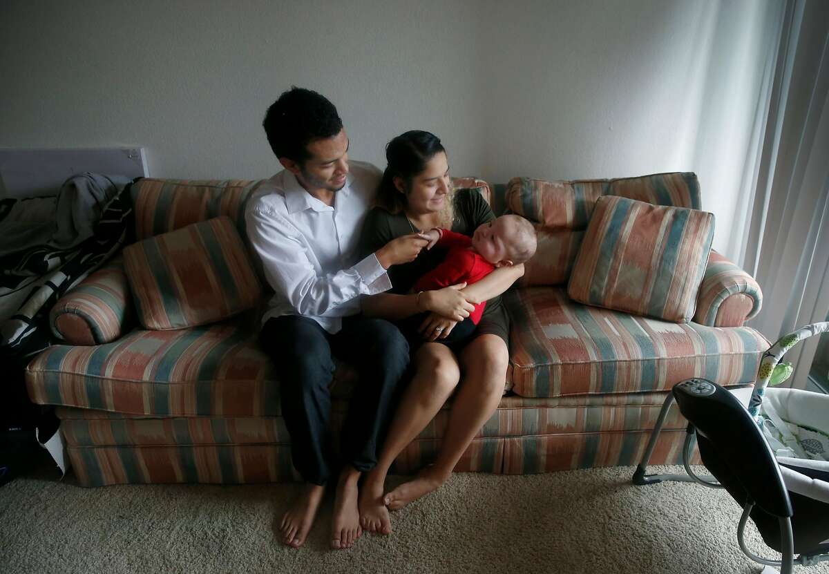 Justin Watson and his wife Citlali Gonzalez-Watson hold 6-month-old son Daniel at their new apartment in Milpitas, Calif. on Friday, Dec. 21, 2018.