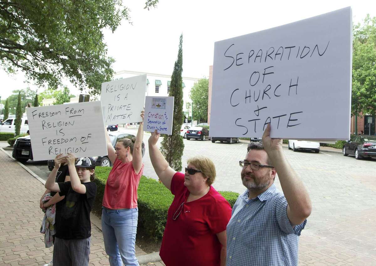 Protesters in 2017 demonstrate against a pre-conference prayer at a news conference by Attorney General Ken Paxton. A minister warns against another threat to separation of chuch and state.