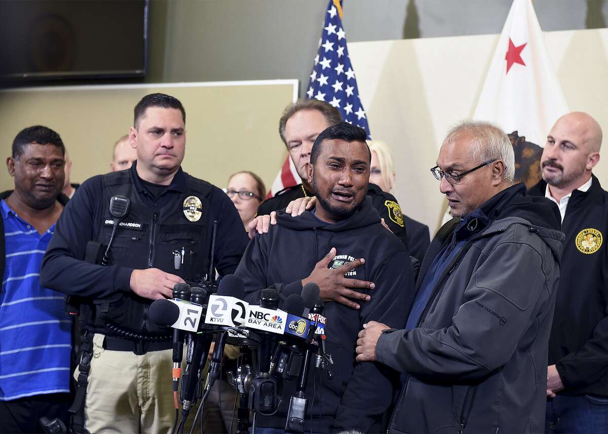 Reggie Singh, brother of Newman Police officer Ronil Singh is overcome with emotion as he thanks law enforcement after the arrest of suspect Gustavo Perez Arriaga and others Friday, Dec. 28, 2018 during a news conference at the Stanislaus County Sheriff's department in Modesto, Calif. Newman Police chief Randy Richardson and Stanislaus County Sheriff Adam Christianson are also pictured. (Joan Barnett Lee/The Modesto Bee via AP)