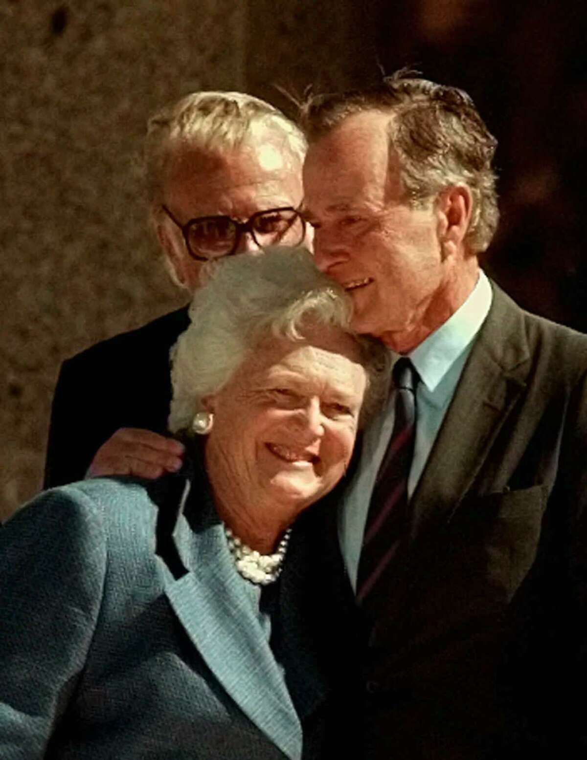 In this Nov. 6, 1997, file photo, former President George H.W. Bush hugs his wife, Barbara, after speaking at the dedication of the George Bush Presidential Library in College Station, Texas. The Bushes were married Jan. 6, 1945, and have had the longest marriage of any presidential couple in American history.