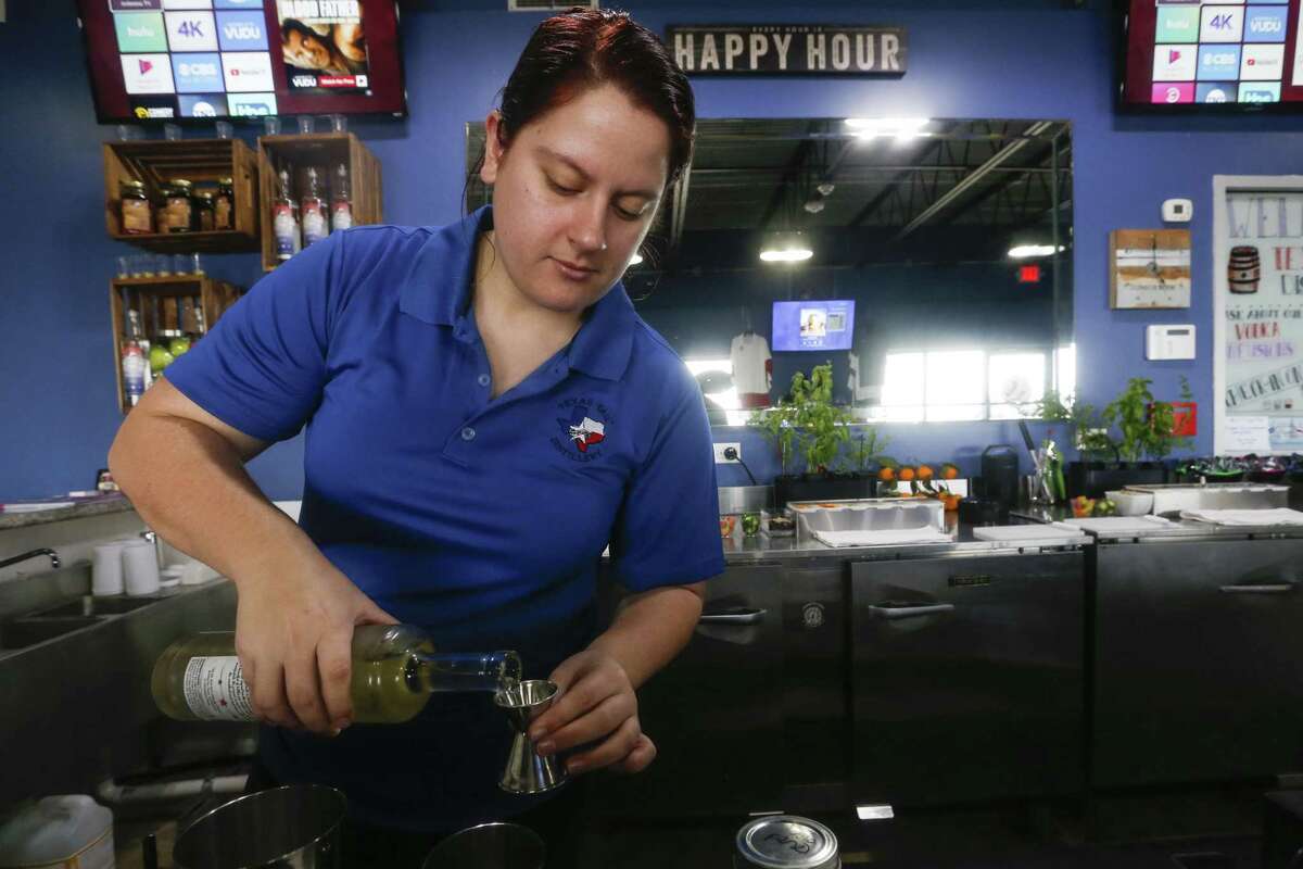Bartender Kayla Van De Flier pours a drink at Texas Tail Distillery's Seawall Boulevard location on Saturday, Dec. 29, 2018, in Galveston. Texas Tail distills moonshine in a variety of flavors. It is an offshoot of Texas Tail vodka, which Greg Truex and partner Nick Droege started in Dallas in 2007.