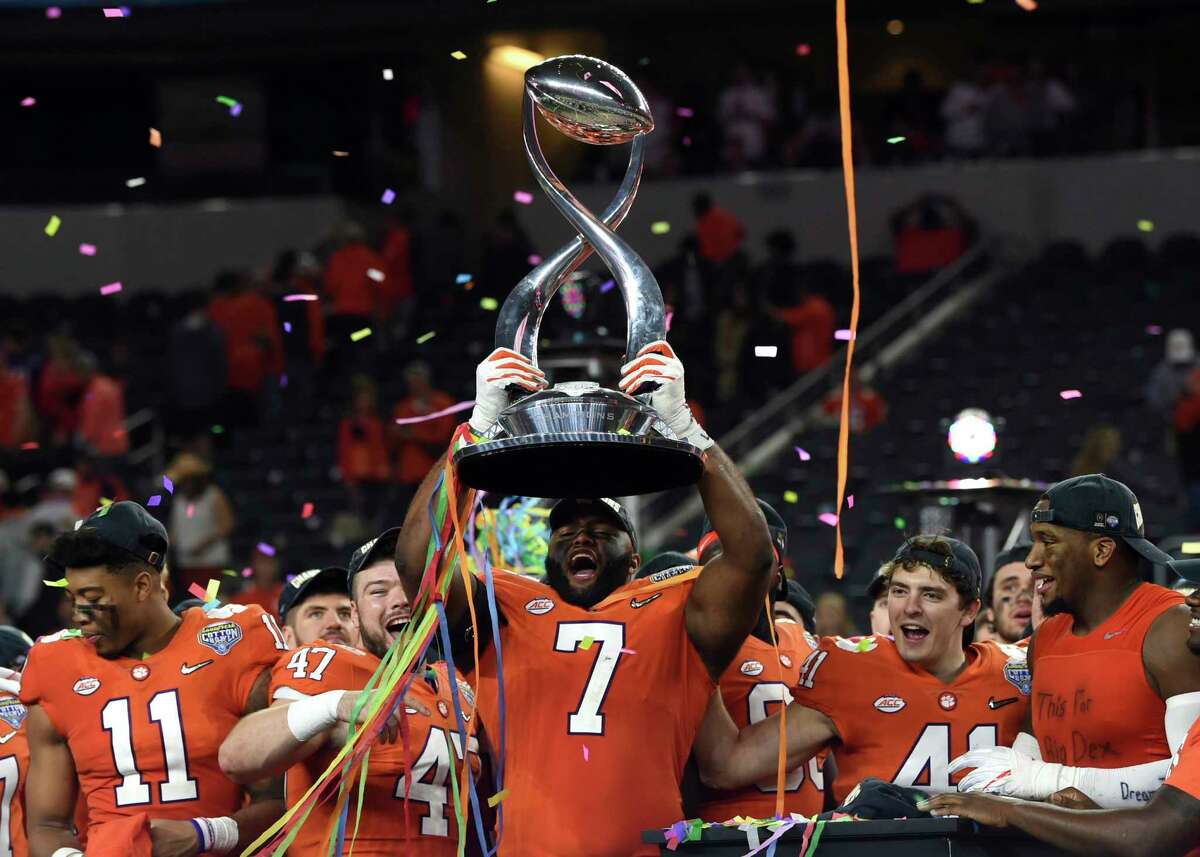 Clemson defensive end Austin Bryant (7) holds up the trophy as the team celebrates their 30-3 win against Notre Dame in the NCAA Cotton Bowl semi-final playoff football game, Saturday, Dec. 29, 2018, in Arlington, Texas. Clemson won 30-3. (AP Photo/Jeffrey McWhorter)