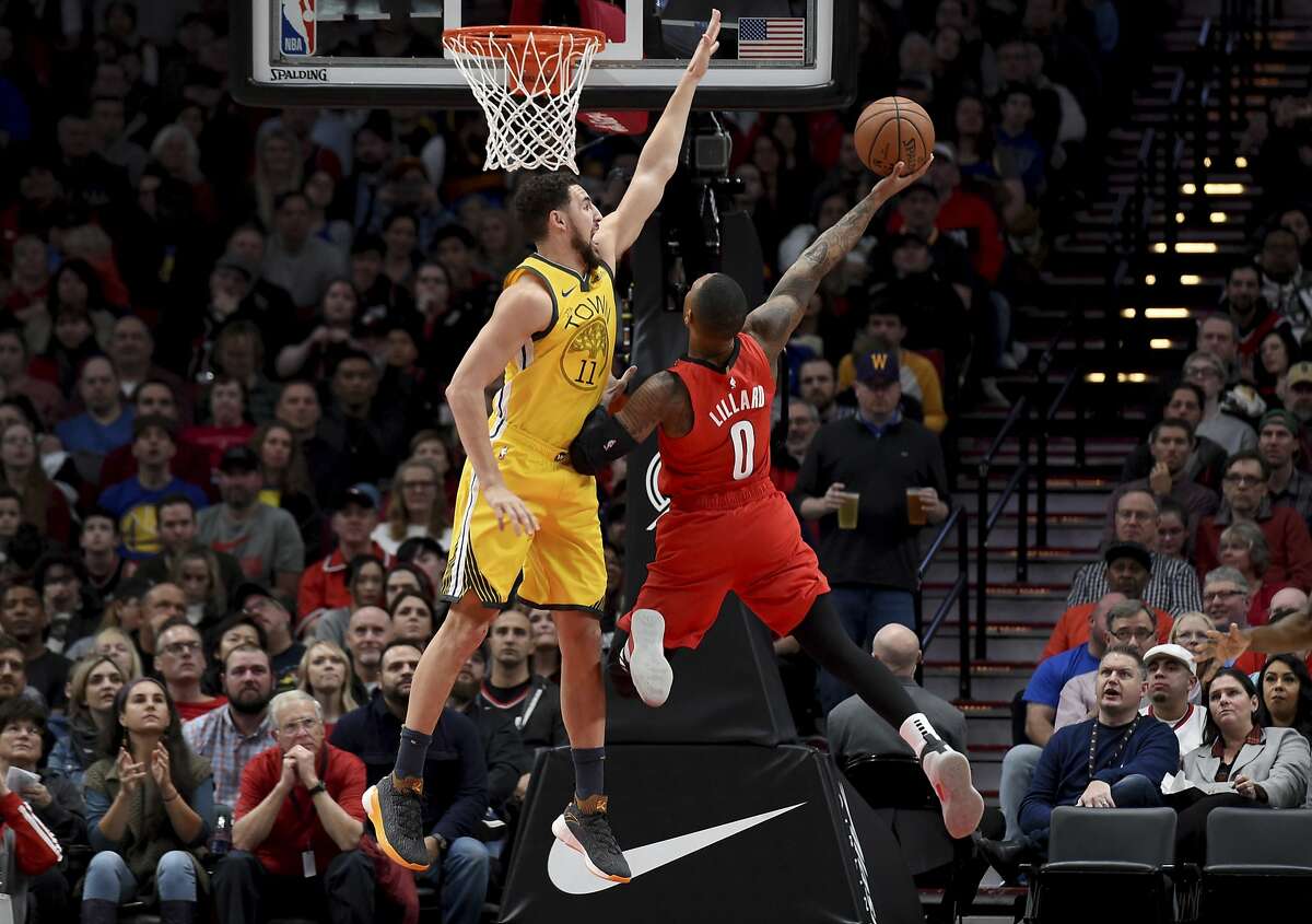 Portland Trail Blazers guard Damian Lillard, right, puts up a shot on Golden State Warriors guard Klay Thompson, left during the first half of an NBA basketball game in Portland, Ore., Saturday, Dec. 29, 2018. (AP Photo/Steve Dykes)