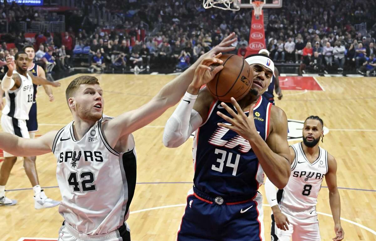 San Antonio Spurs forward Davis Bertans, left, reaches for a rebound as Los Angeles Clippers forward Tobias Harris grabs it while guard Patty Mills, right, watches during the first half of an NBA basketball game Saturday, Dec. 29, 2018, in Los Angeles. (AP Photo/Mark J. Terrill)
