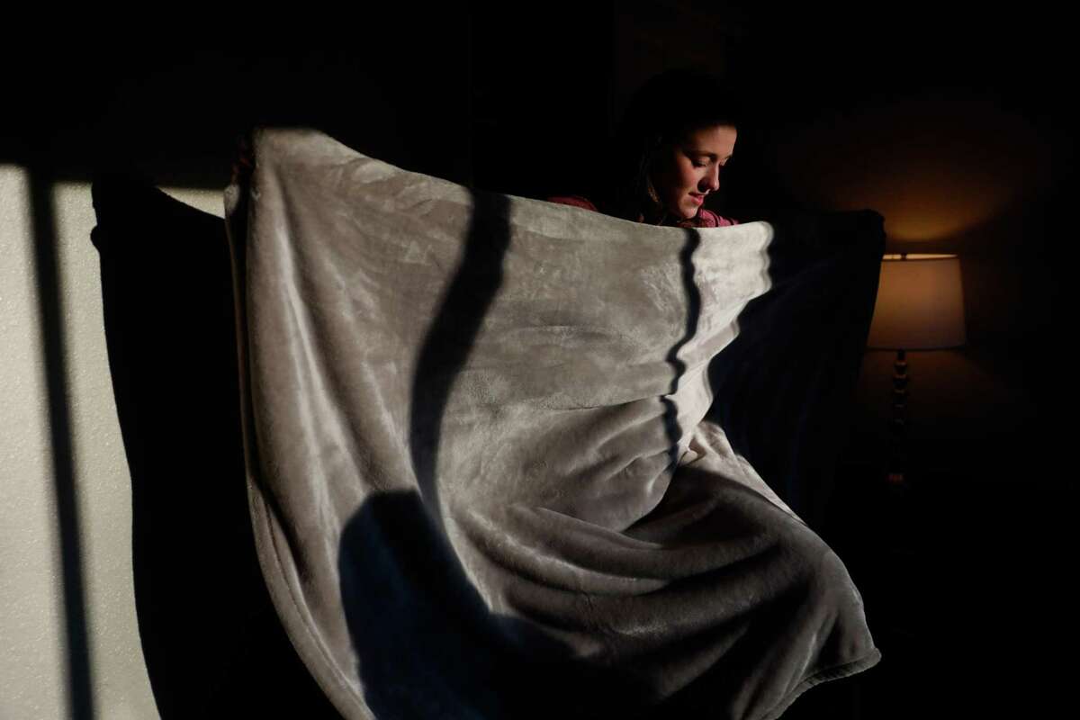 Faith Brown folds a blanket as she moves into her new apartment in Chico on Monday, December 10, 2018. Faith and her family lost their home in the Camp Fire in Paradise.