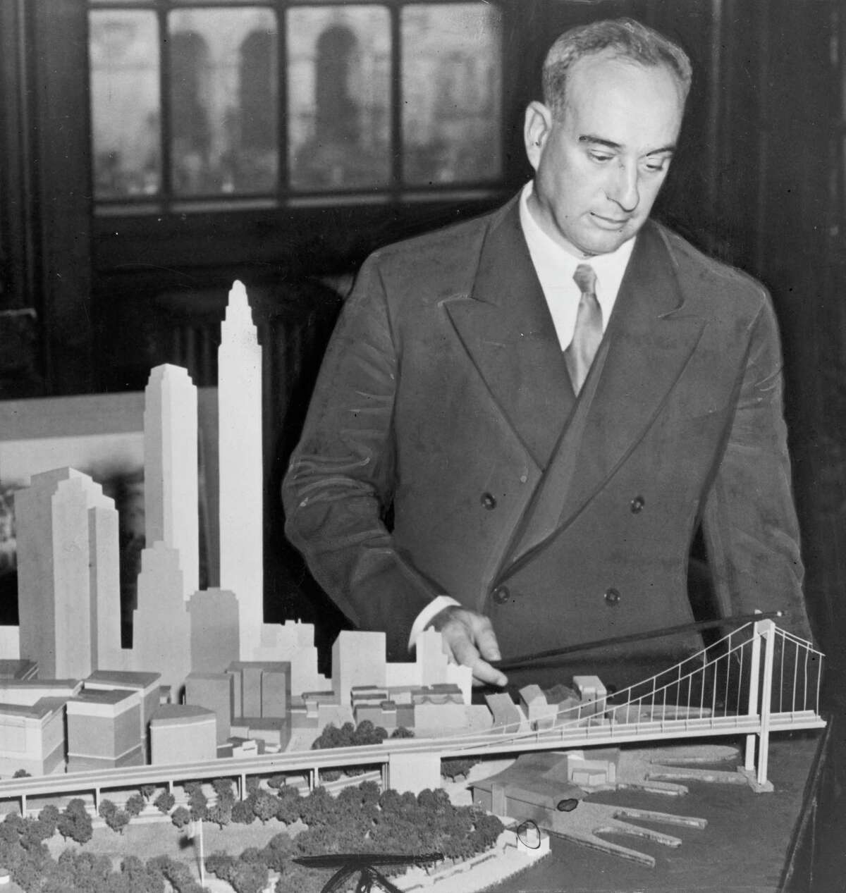 New York City Park Commissioner Robert Moses with a model of the proposed, but never built Brooklyn Battery Bridge in New York in 1939.