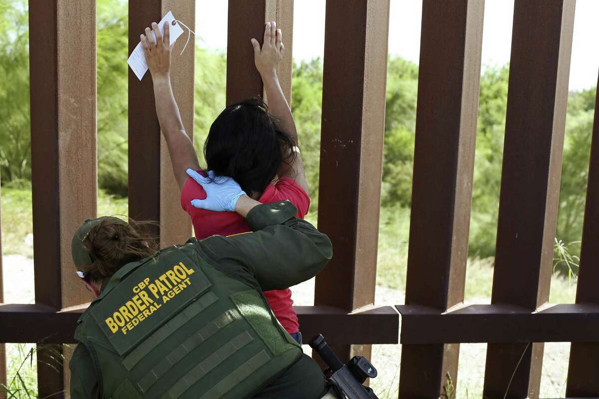 U.S Border Patrol Agent Amber Peterson pats-down Santos Abel Madriges, 34, from El Salvador, in Hidalgo County near McAllen, Texas, Thursday, July 19, 2018. Madriges was traveling with her 17-year-old son and together with a group of seven immigrants from Central America, turned themselves into authorities after illegally crossing the Rio Grande into the U.S.