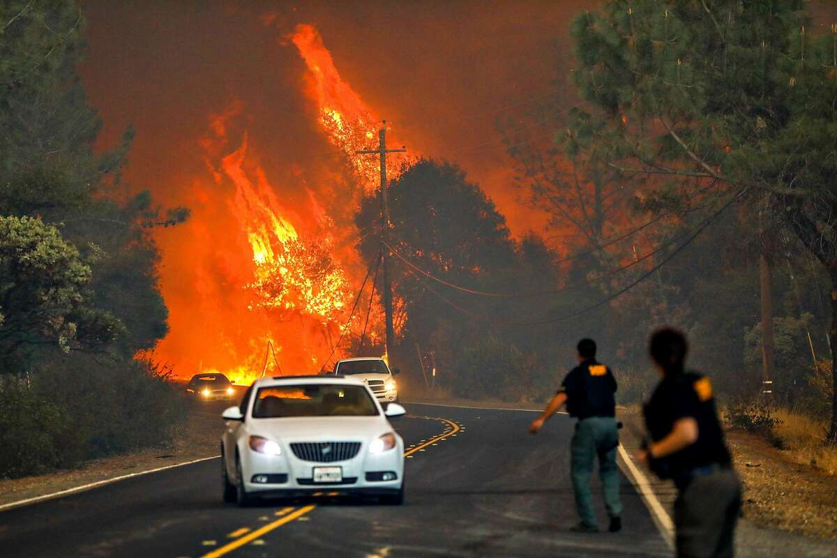 Sheriffs evacuating drivers during the Camp Fire in Paradise, California, on Thursday, Nov. 8, 2018. The cost of wildfire destruction in California has soared, leading some state leaders to consider ways to institute statewide insurance for utilities and for firefighting costs.