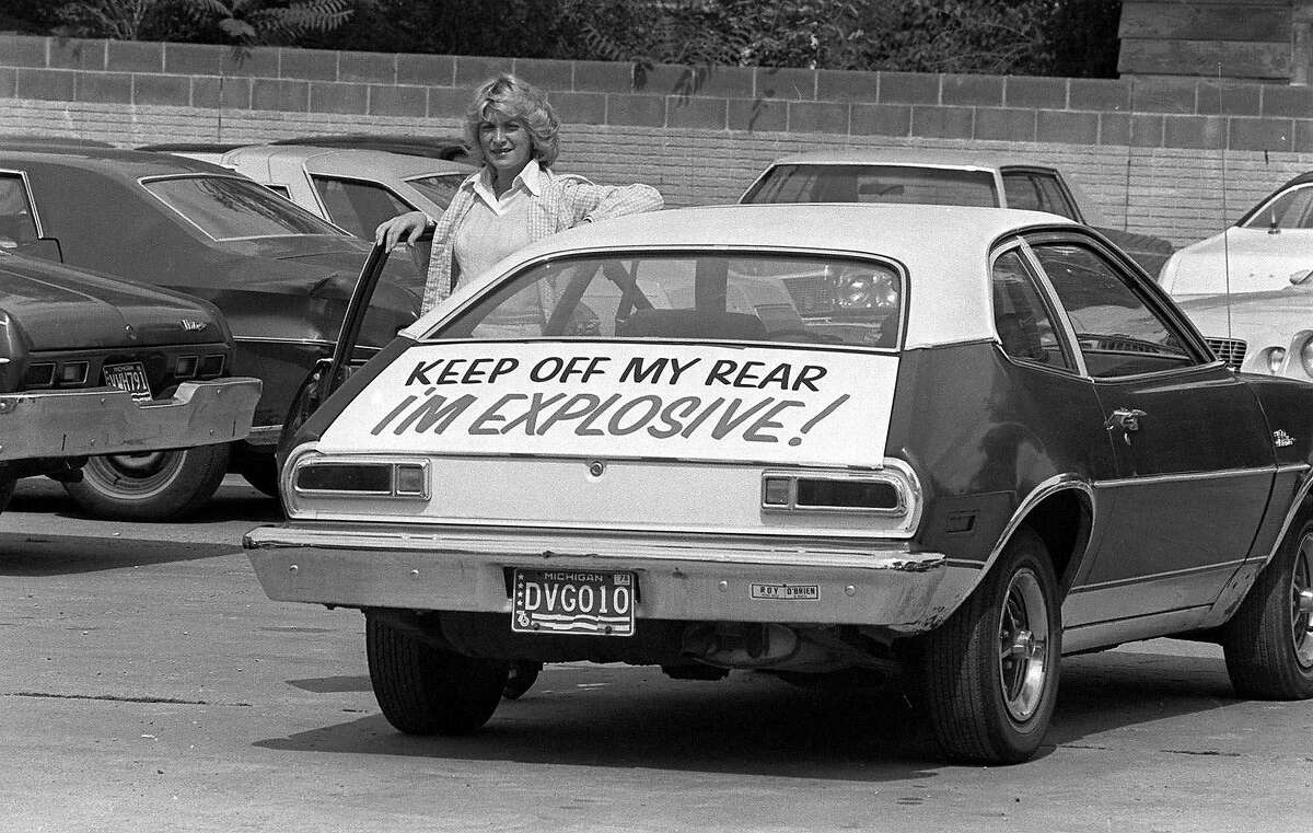 Patty Ramge, posing Sept.1,1978 with her 1975 Ford Pinto, has little trouble with motorists tailgating since she decked her car with a sign warning of its' explosive nature if hit from the rear. Mrs. Ramge posted the warning after weeks of trying to convince Ford Motor Co., and its dealers to modify the fuel tank so it would not pose a fire hazard in a rear-end crash. (AP Photo/jch)