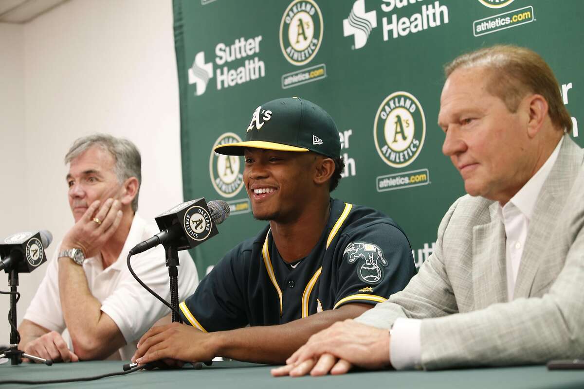 OAKLAND, CA - JUNE 15: Executive Vice President of Baseball Operations Billy Beane of the Oakland Athletics, first round draft pick Kyler Murray and Agent Scott Boras talk during a press conference after Murray signed his contact at the Oakland Alameda Co