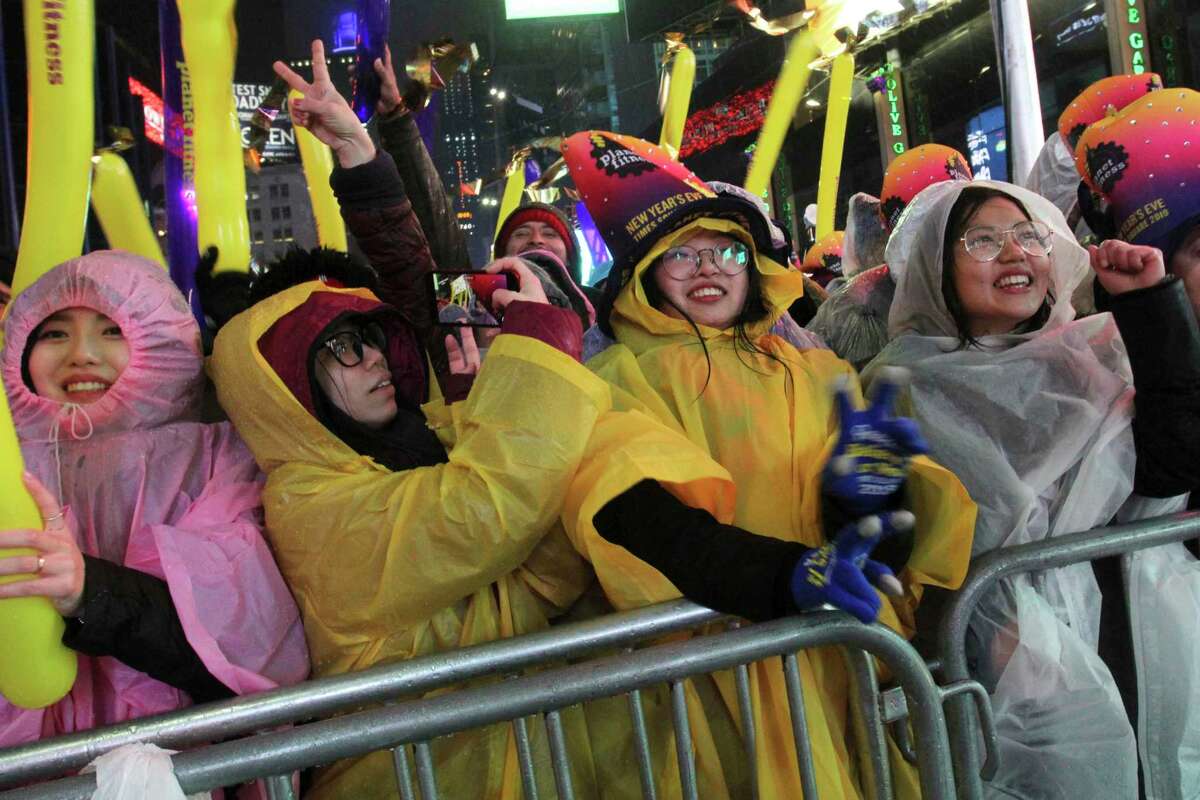 Ting Ouyang, from Philadelphia, Pa., right, and others take part in the New Year's Eve festivities in New York's Times Square, Monday, Dec. 31, 2018.
