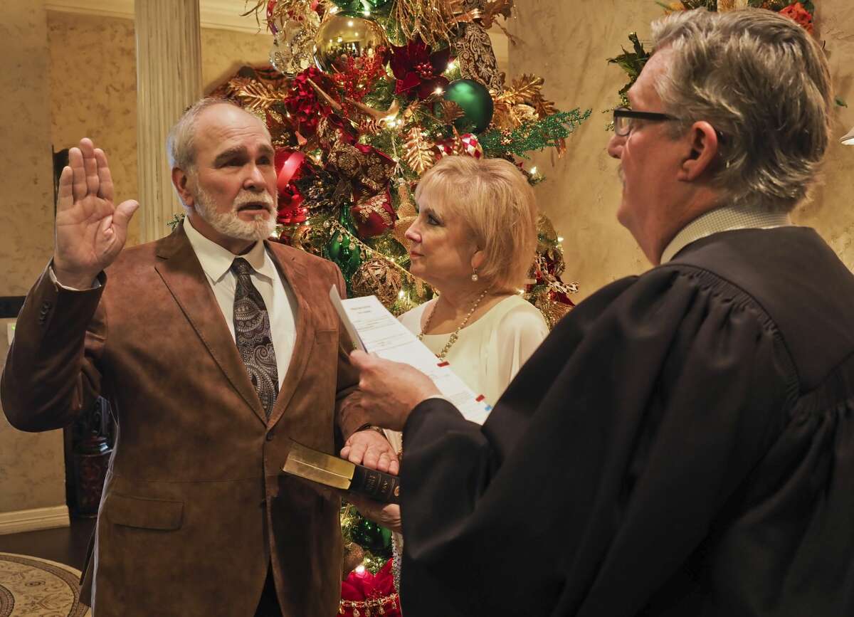 Terry Johnson receives his oath of office as the new Midland County Judge 01/01/19 from Judge David Lindemood as Paula Johnson holds his Bible during a ceremony at theJohnson home. Tim Fischer/Reporter-Telegram